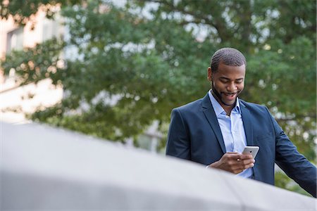 Summer. A Man In A Blue Jacket And Open Collared Shirt Using A Smart Phone. Stock Photo - Premium Royalty-Free, Code: 6118-07121857