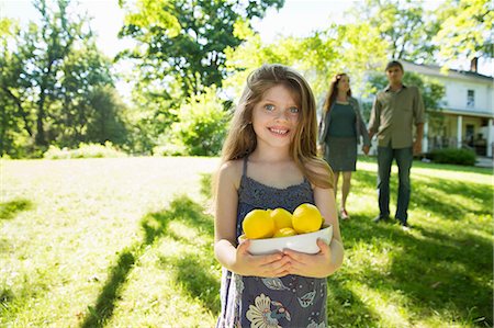 simsearch:6118-07351124,k - Farm. Children And Adults Working Together. A Girl Holding A Crate Of Lemons, Fresh Fruits. Two Adults In The Background. Stock Photo - Premium Royalty-Free, Code: 6118-07121814