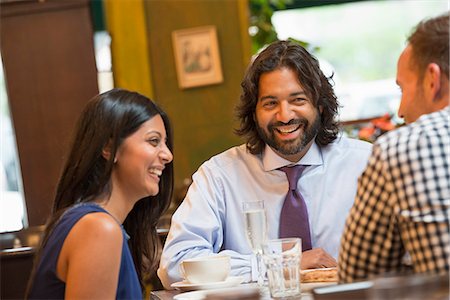 simsearch:6118-07122298,k - Business People. Three People Seated Around A Table In A Bar Or Cafe, Having Drinks. Stock Photo - Premium Royalty-Free, Code: 6118-07121940