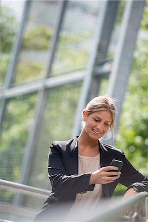 simsearch:6118-08243810,k - A Young Blonde Businesswoman On A New York City Street. Wearing A Black Jacket. Using A Smart Phone. Stock Photo - Premium Royalty-Free, Code: 6118-07121962