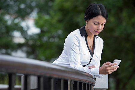 simsearch:6118-07121993,k - Business People. A Woman In A White Jacket Checking Her Phone. Stock Photo - Premium Royalty-Free, Code: 6118-07121990