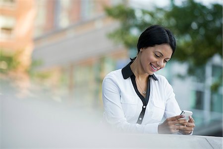 simsearch:6118-07121866,k - Business People. A Woman In A White Jacket Checking Her Phone. Stock Photo - Premium Royalty-Free, Code: 6118-07121992