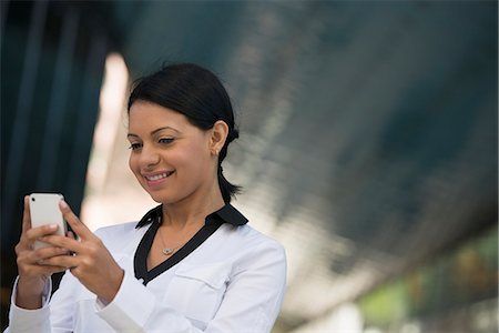 simsearch:6118-07121866,k - Business People. A Woman In A White Jacket Checking Her Phone. Stock Photo - Premium Royalty-Free, Code: 6118-07121994
