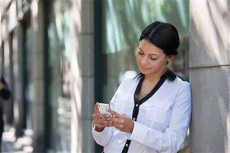 simsearch:6118-07121866,k - Business People. A Woman In A White Jacket Checking Her Phone. Stock Photo - Premium Royalty-Free, Code: 6118-07121996