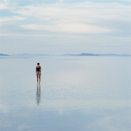 saltflat - A Woman Standing On The Flooded Bonneville Salt Flats, At Dusk. Stock Photo - Premium Royalty-Free, Code: 6118-07122083