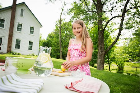simsearch:6118-07122147,k - A Summer Family Gathering At A Farm. A Girl Cutting And Juicing Lemons, To Make Lemonade. Stock Photo - Premium Royalty-Free, Code: 6118-07122150