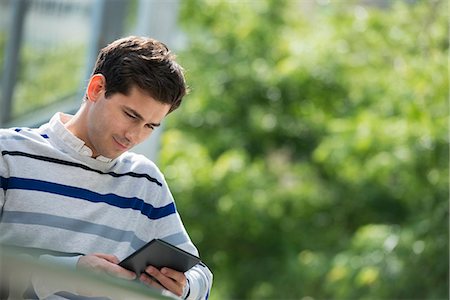 Summer. Business People. A Man Sitting Using A Digital Tablet, Keeping In Touch. Stock Photo - Premium Royalty-Free, Code: 6118-07122265