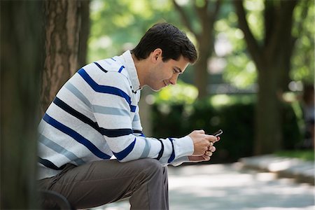 Summer. Business People. A Man Checking His Smart Phone For Messages. Stock Photo - Premium Royalty-Free, Code: 6118-07122282