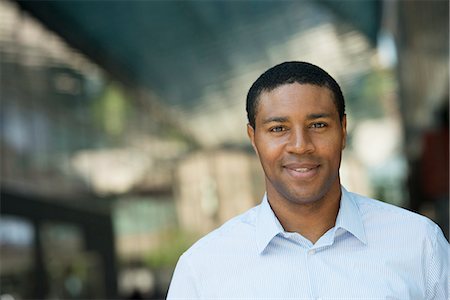 Business People On The Move. A Man In An Open Necked Shirt Smiling. Stock Photo - Premium Royalty-Free, Code: 6118-07122286