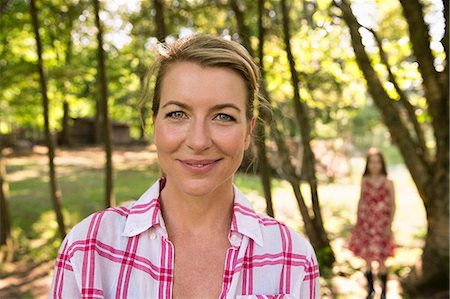 simsearch:6122-07698008,k - A Mother And Daughter In The Shade Of Trees Outside In Summer. Stock Photo - Premium Royalty-Free, Code: 6118-07122212