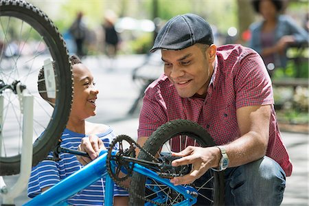 family on bicycle in park - A Family In The Park On A Sunny Day. A Father And Son Repairing A Bicycle. Stock Photo - Premium Royalty-Free, Code: 6118-07122511