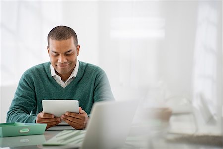 person sits on the chair and front view - Business. A Light Airy Office Environment. A Man Sitting Holding A Digital Tablet. Stock Photo - Premium Royalty-Free, Code: 6118-07122609