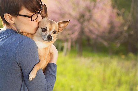 simsearch:6118-07122740,k - A Young Woman In A Grassy Field In Spring. Holding A Small Chihuahua Dog In Her Arms. A Pet. Photographie de stock - Premium Libres de Droits, Code: 6118-07122748