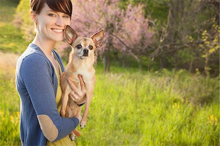simsearch:6118-07122740,k - A Young Woman In A Grassy Field In Spring. Holding A Small Chihuahua Dog In Her Arms. A Pet. Photographie de stock - Premium Libres de Droits, Code: 6118-07122749