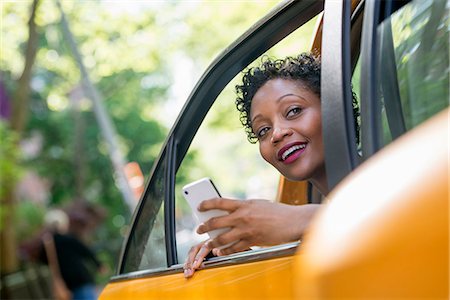 people looking phones - A Woman Sitting In The Rear Passenger Seat Of A Yellow Cab, Checking Her Phone. Foto de stock - Sin royalties Premium, Código: 6118-07122770