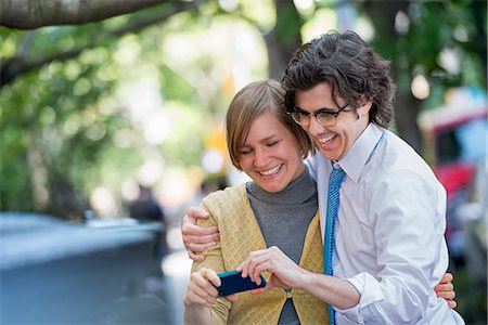 simsearch:6118-07440408,k - City. Two People, A Man And Woman Outdoors, Looking At A Smart Phone Together. Stock Photo - Premium Royalty-Free, Code: 6118-07122797