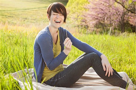 simsearch:6118-07122740,k - A Young Woman Sitting In An Open Space, A Grass Field, On A Blanket. Photographie de stock - Premium Libres de Droits, Code: 6118-07122733