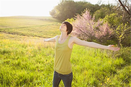 simsearch:6118-07122740,k - Young Woman Standing In Grassy Field In Spring. Photographie de stock - Premium Libres de Droits, Code: 6118-07122735