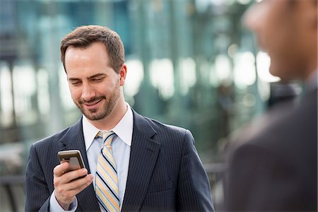simsearch:6118-07121866,k - City. A Man In A Business Suit Checking His Messages On His Smart Phone. Stock Photo - Premium Royalty-Free, Code: 6118-07122835