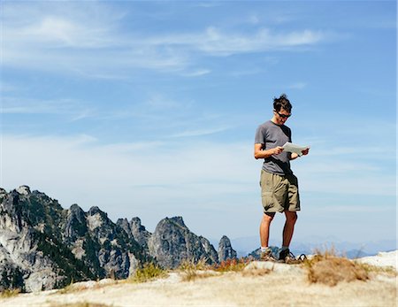 explorer - A hiker on the mountain summit, looking at a map. Surprise Mountain, Alpine Lakes Wilderness, in Mount Baker-Snoqualmie National Forest, Foto de stock - Sin royalties Premium, Código: 6118-07202946