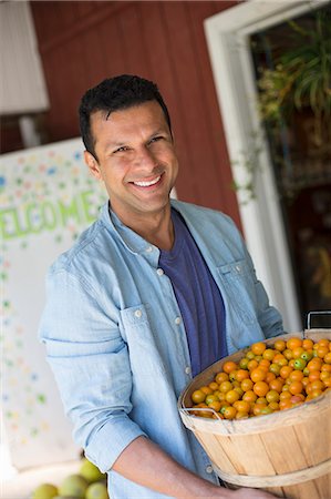 denim shirt - A farm growing and selling organic vegetables and fruit. A man holding a bowl of basket of freshly picked tomatoes. Foto de stock - Sin royalties Premium, Código: 6118-07202976