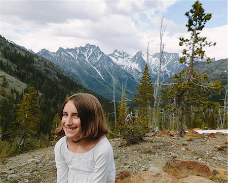 evergreen tree - A young girl sitting at a lookout point, with a view over the mountains of Wenatchee national forest. Stock Photo - Premium Royalty-Free, Code: 6118-07202936