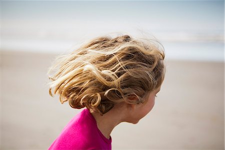 A six year old child on the beach, at Long Beach Peninsula with windblown hair. Stock Photo - Premium Royalty-Free, Code: 6118-07203178