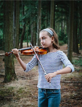 A ten year old girl playing the violin in Discovery Park, Seattle. Stock Photo - Premium Royalty-Free, Code: 6118-07203255