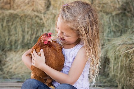 simsearch:6118-07354442,k - A young girl holding a chicken in a henhouse. Stock Photo - Premium Royalty-Free, Code: 6118-07203309