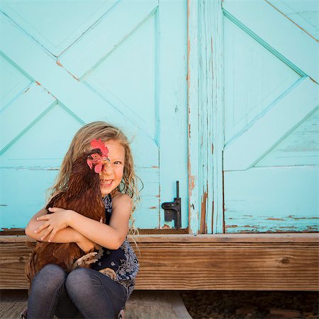 A young girl holding a chicken in her arms. Stock Photo - Premium Royalty-Free, Code: 6118-07203319