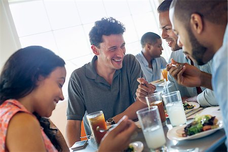 A group of men and women in a cafe, having drinks and enjoying each other's company. Stock Photo - Premium Royalty-Free, Code: 6118-07203491