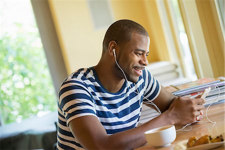 simsearch:6118-07203820,k - A man sitting in a cafe, having a cup of coffee, listening to music with headphones. Stock Photo - Premium Royalty-Free, Code: 6118-07203780