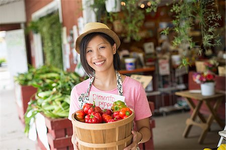 A woman working on an organic farm stand, displaying fresh vegetables for sale. Stock Photo - Premium Royalty-Free, Code: 6118-07203868