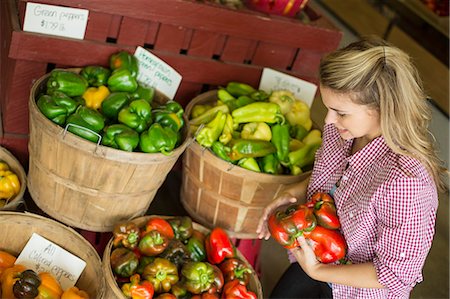 simsearch:6118-07808971,k - Working on an organic farm. A young blonde haired woman sorting different types of bell pepper for sale. Stock Photo - Premium Royalty-Free, Code: 6118-07203871