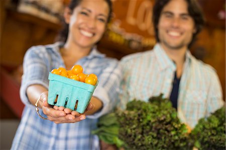 simsearch:6118-07203696,k - Two people with baskets of tomatoes and curly green leafy vegetables. Working on an organic farm. Stock Photo - Premium Royalty-Free, Code: 6118-07203878