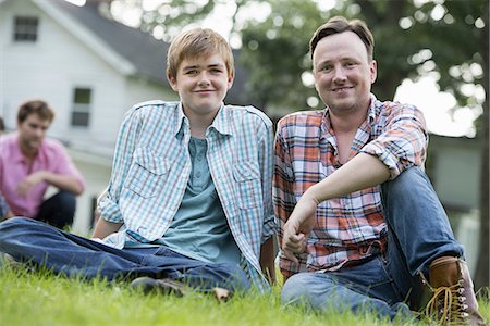 farm and boys - A father and son at a summer party, sitting on the grass. Stock Photo - Premium Royalty-Free, Code: 6118-07235264