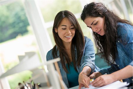 simsearch:6118-07351363,k - Two women working together, looking at the screen of a digital tablet. Stock Photo - Premium Royalty-Free, Code: 6118-07351173