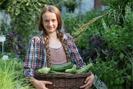 simsearch:6118-07351124,k - Summer on an organic farm. A girl holding a basket of fresh marrows. Stock Photo - Premium Royalty-Free, Code: 6118-07351133
