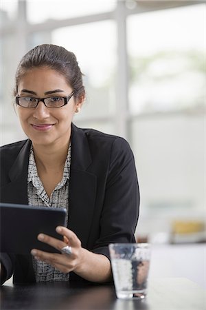 simsearch:6118-07351363,k - Young professionals at work. A woman wearing a black jacket, using a black digital tablet. Stock Photo - Premium Royalty-Free, Code: 6118-07351365