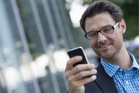 Business people in the city. Keeping in touch on the move. A man using his smart phone. Photographie de stock - Premium Libres de Droits, Code: 6118-07351491