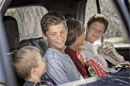 simsearch:6118-07354031,k - Four boys sitting in a car or truck, in a row. Stock Photo - Premium Royalty-Free, Code: 6118-07352173
