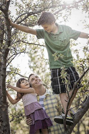 simsearch:673-02801432,k - An adult with two children climbing trees. Stock Photo - Premium Royalty-Free, Code: 6118-07352180