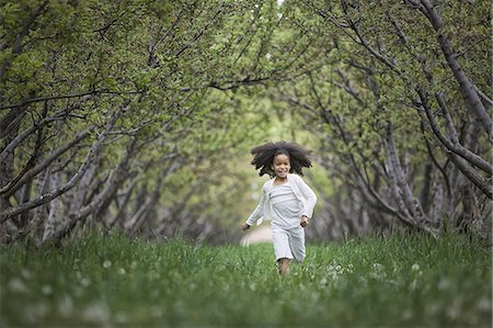 environmental hazard - A child running along a natural woodland tunnel with tree branches forming an arch. Stock Photo - Premium Royalty-Free, Code: 6118-07352206