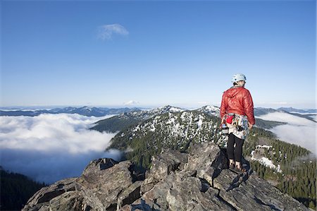 risk mountain - A rock climber stands on the summit of a peak after climbing to the top with the aid of a rope and protection. Stock Photo - Premium Royalty-Free, Code: 6118-07352538