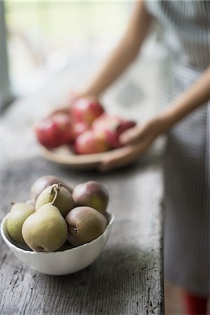 simsearch:6118-07354433,k - A person preparing organic fresh produce in a kitchen. Tray of red apples.  Bowl of pears. Stock Photo - Premium Royalty-Free, Code: 6118-07352629