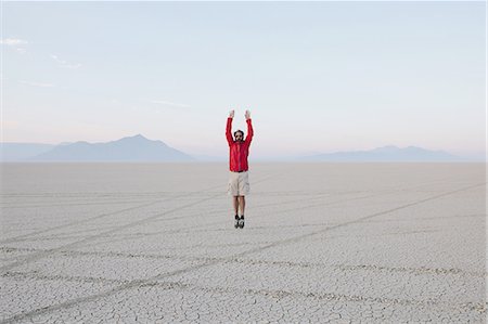 simsearch:6118-07352742,k - A man jumping in the air on the flat desert or playa or Black Rock Desert, Nevada. Stock Photo - Premium Royalty-Free, Code: 6118-07352749