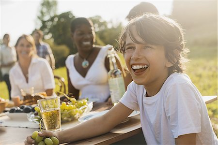 picnic family laugh - A family and friends having a meal outdoors.  A picnic or buffet in the early evening. Stock Photo - Premium Royalty-Free, Code: 6118-07352826