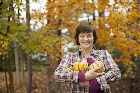 simsearch:6118-07353446,k - Organic farm. A woman holding an armful of large squash vegetables. Stock Photo - Premium Royalty-Free, Code: 6118-07353454