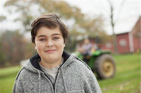 simsearch:6118-07353446,k - A boy on an organic farm beside a small tractor. Stock Photo - Premium Royalty-Free, Code: 6118-07353439