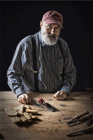 simsearch:649-07560393,k - A man working in a reclaimed lumber yard workshop. Holding tools and working on a knotted and uneven piece of wood. Photographie de stock - Premium Libres de Droits, Code: 6118-07353645